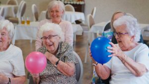 Older adults packing boxes with family and arranging personal items in a bright, comfortable room.
